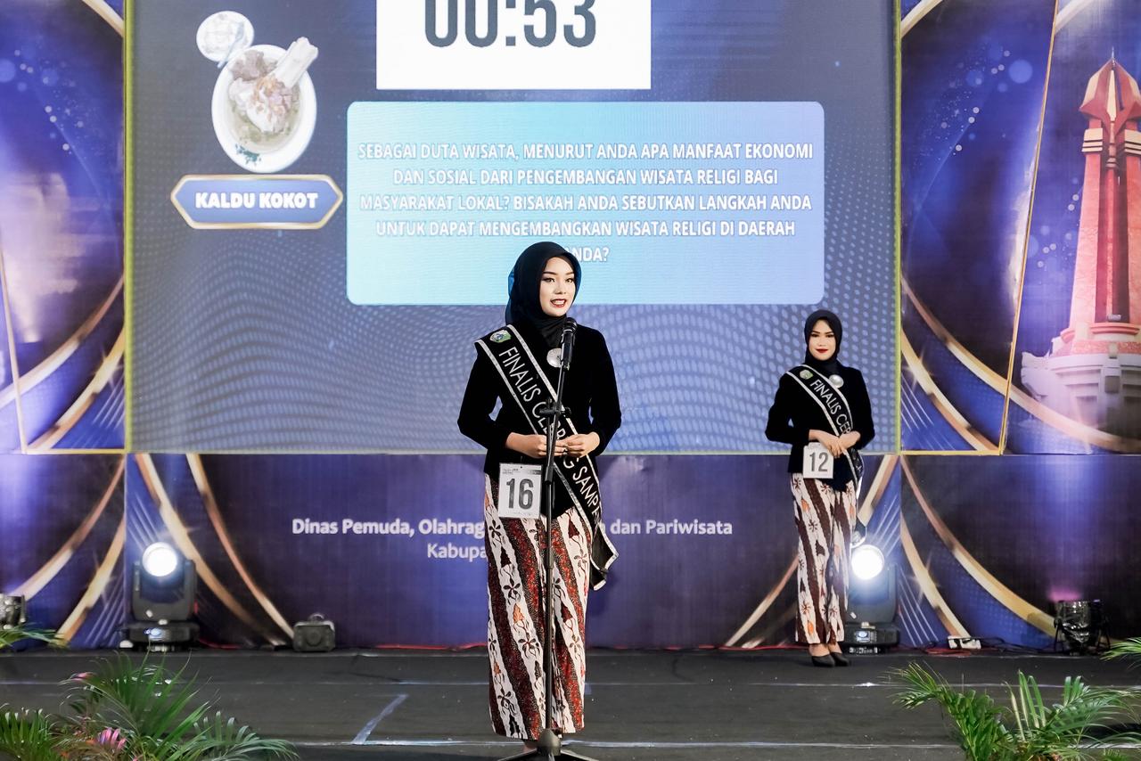 Finalis Duta Wisata Cebbing Sampang 2025, yang juga adalah mahasiswa S1 Akuntansi FEB Unmer Malang, Nazwa Alisya Fatiha (NIM. 25023000122), sedang menjawab pertanyaan yang diajukan oleh dewan juri dalam penampilannya di Grand Final Pemilihan Duta Wisata Kacong - Cebbing Kabupaten Sampang 2025, Minggu (16/11).