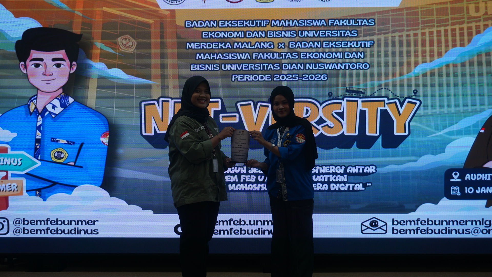 Momen pertukaran cenderamata antara BEM FEB UDINUS Semarang dan BEM FEB Unmer Malang di Auditorium I6 UDINUS Semarang, Sabtu (10/1), yang dilakukan oleh Gubernur BEM FEB UDINUS Semarang, Eka Lidya Rahmawati (kiri) dan Ketua Umum BEM FEB Unmer Malang, Nadya Ayu Andini (kanan).